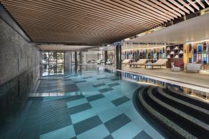 a swimming pool with a checkered floor in a building at Hôtel Barrière Les Neiges Courchevel in Courchevel