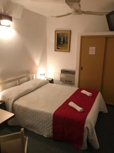 a bedroom with a bed with two towels on it at Hotel Antares in Montevideo