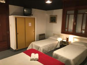 a hotel room with two beds and a tv at Hotel Antares in Montevideo