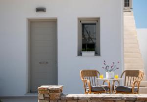 a patio with two chairs and a table and a door at Angelique Apartment in Antiparos