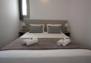 a bedroom with a large bed with two towels on it at Angelique Apartment in Antiparos
