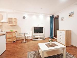 Il dispose d'une cuisine et d'un salon avec une télévision et une table. dans l'établissement City Dwor Apartament, à Gdańsk
