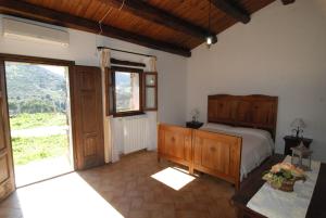 a bedroom with a bed and a large window at Stazzu Coiga in Aggius