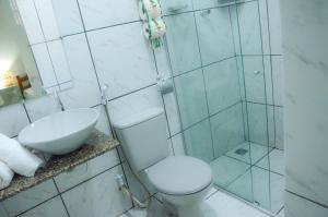 a bathroom with a shower and a toilet and a sink at Vila Mar in Fernando de Noronha
