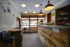 a bar with a wooden counter and a wooden barrel at Hotel Stoh in Špindlerův Mlýn