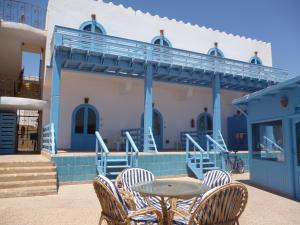 een patio met stoelen en een tafel voor een gebouw bij El Primo Hotel Dahab in Dahab