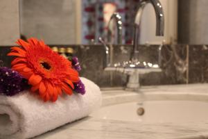 a red flower sitting on a towel in a bathroom sink at Prince de Conde in Paris