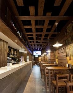 Un restaurante con mesas y sillas y un bar. en Pension Restaurante Casa Camiño, en Palas de Rei 