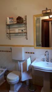 a bathroom with a toilet and a sink and a mirror at Residenza Il Platano Fortilizio di Campiglia in Rapolano Terme +27 photos