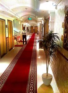 a man walking down a red carpet in a hallway at Nawarah Al Takhassusi in Riyadh
