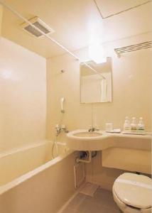 a bathroom with a sink and a toilet and a tub at Tendo Central Hotel in Tendo