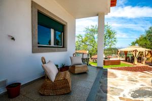 eine Terrasse mit 2 Stühlen und einem Fenster zum Haus in der Unterkunft Casa Da Nora in Salgueiro do Campo