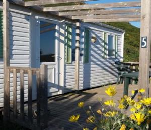 a tiny house with a porch and a table at La Canardiere in Casta