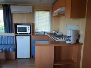 a small kitchen with a refrigerator and a microwave at La Canardiere in Casta