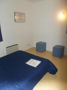 a bedroom with a blue bed and two blue stools at Résidence L'Océane, Andernos in Andernos-les-Bains +10 photos