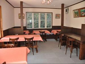 een eetkamer met tafels en stoelen en een raam bij Poetical in Matsumoto