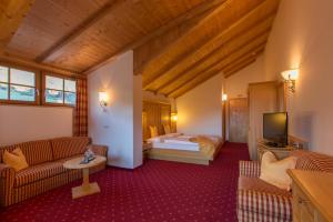 um quarto de hotel com uma cama e uma televisão em Berghotel Johanneshof em Anterselva di Mezzo