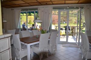 a dining room with a table and white chairs at Romantikmühle Heartlandranch in Krummenau