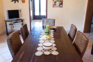 a wooden table with chairs around it with a bowl on it at Villa Rose in Marina di Mancaversa