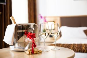 a table with two glasses of wine on a table at Hotel Portici - Romantik & Wellness in Riva del Garda