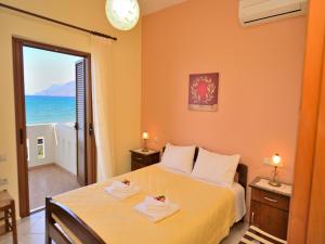 een slaapkamer met een bed en uitzicht op de oceaan bij Niriides Apartments in Kissamos