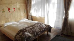 Bett in einem Zimmer mit Fenster in der Unterkunft B&B La Locanda del Colle e ristorante in Limone Piemonte