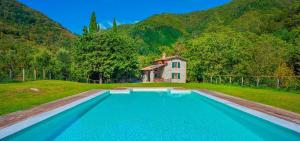 a large swimming pool in front of a house at Casa Pescaglia in Pescaglia