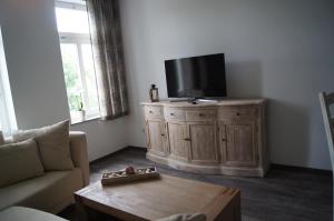 a living room with a flat screen tv on a wooden cabinet at Ferienwohnung Markkleeberg Ost-See in Markkleeberg