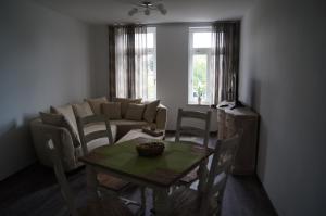 a living room with a table and a couch at Ferienwohnung Markkleeberg Ost-See in Markkleeberg +9 photos