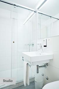 a bathroom with a sink, toilet and mirror at Serviced Apartments by Solaria in Davos