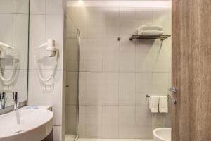 a white bathroom with a shower and a sink at Warmthotel in Rome
