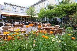 a patio with tables and chairs and flowers at Hotel La Strada in Kassel