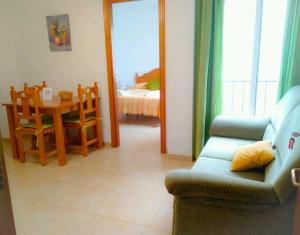 1 dormitorio y sala de estar con sofá y mesa. en Apartamentos Centurión, en Nerja