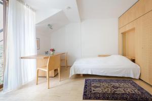 Schlafzimmer mit einem Bett, einem Schreibtisch und einem Tisch in der Unterkunft Frühstückspension "Schlosswirt" in Ossiach