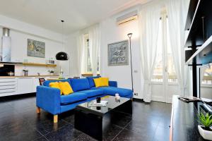 - un salon avec un canapé bleu et des oreillers jaunes dans l'établissement ALTIDO Colorful Studio for 2 near city life, à Milan