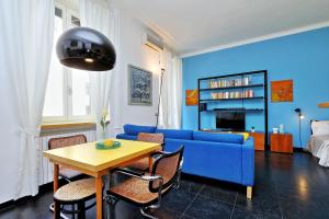 - un salon avec un canapé bleu et une table dans l'établissement ALTIDO Colorful Studio for 2 near city life, à Milan