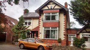 a orange car parked in front of a house at Spacious King Bedroom in Grantham Lincolnshire in Grantham