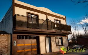 Un edificio con un balcón en la parte superior. en Singlar Consultora, en Malargüe