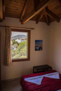 a bedroom with a bed and a large window at Elena's House in Artemida