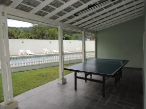a ping pong table on a screened in porch at Casinha de Boneca em Juquey in Juquei