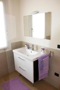 a bathroom with a sink and a mirror and purple towel at i mirtilli in Pianezze +21 photos