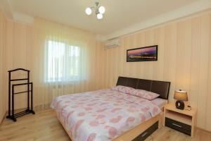 a bedroom with a large bed and a window at Apartment on Obolonskiy Prospect 16V in Kyiv