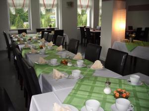 a long table with green and white tables and chairs at Greizer Kammhütte Gaststätte & Pension in Klingenthal