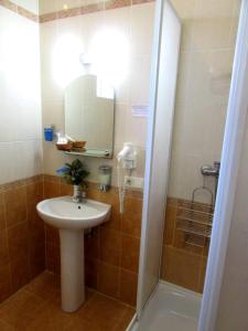 La salle de bains est pourvue d'un lavabo et d'une douche avec un miroir. dans l'établissement Old Town, à Izmaïl
