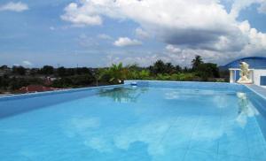 a large blue swimming pool with a sky background at Hotel Mitra Garden in Pangkalpinang