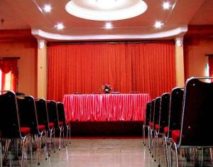 a room with a table with chairs and a red curtain at Hotel Mitra Garden in Pangkal Pinang +21 photos