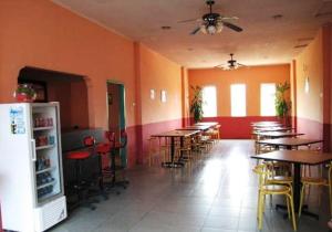 a restaurant with tables and chairs in a room at Hotel Mitra Garden in Pangkal Pinang