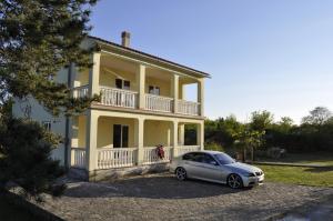 a car parked in front of a large house at Apartments Zecevic in Vrh