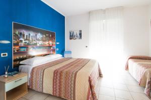 a bedroom with a large bed and a blue wall at Hotel Villa Cesare B&B in Alba Adriatica