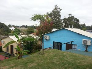 una casa azul sentada en la cima de una colina en Bungalows Atardecer Apart Hotel, en Atlántida